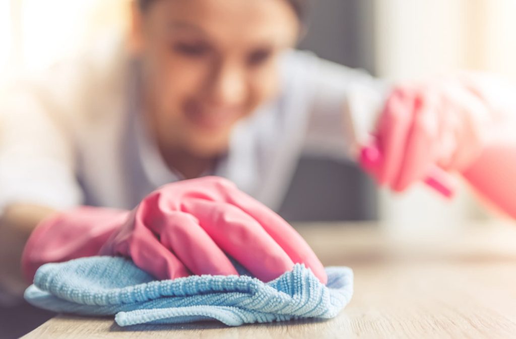 Person wiping down the counter with a blue cloth.