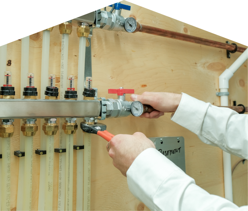 Furnasman HVAC specialist performing boiler repair, adjusting internal components of a residential unit with visible copper piping and control wiring. Furnasman HVAC specialist performing boiler repair, adjusting internal components of a residential unit with visible copper piping and control wiring.