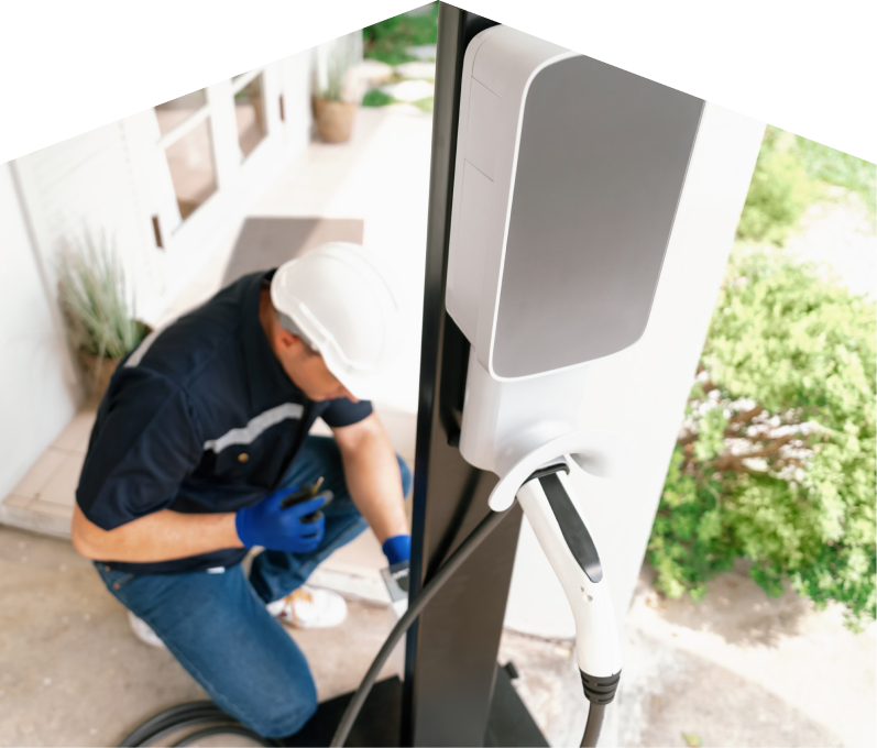 Home service electrician from Furnasman installing an EV charger fixed to a vertical post near a residential entryway. Home service electrician from Furnasman installing an EV charger fixed to a vertical post near a residential entryway.