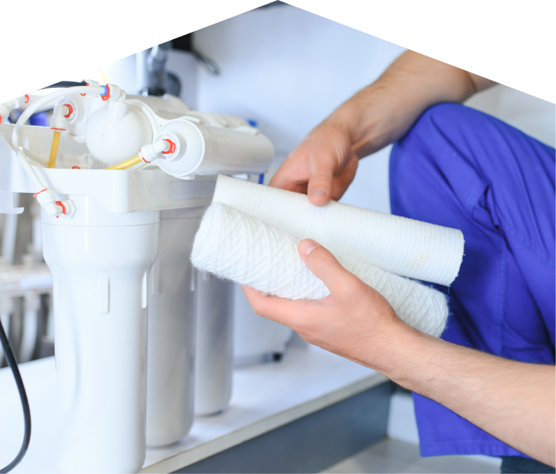 Furnasman water filtration specialist replacing filter cartridges on a reverse osmosis water system installed under a sink. Furnasman water filtration specialist replacing filter cartridges on a reverse osmosis water system installed under a sink.