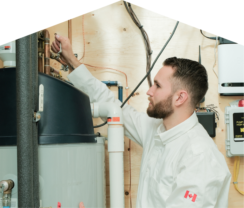 Furnasman water heater specialist adjusts piping on a large residential unit during a repair service, with exposed wood paneling and mounted utility components in the background. Furnasman water heater specialist adjusts piping on a large residential unit during a repair service, with exposed wood paneling and mounted utility components in the background.