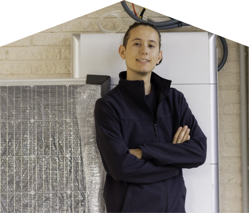 Furnasman specialist standing confidently with arms crossed beside newly delivered system components, including a wrapped panel and wall-mounted utility unit. Furnasman specialist standing confidently with arms crossed beside newly delivered system components, including a wrapped panel and wall-mounted utility unit.